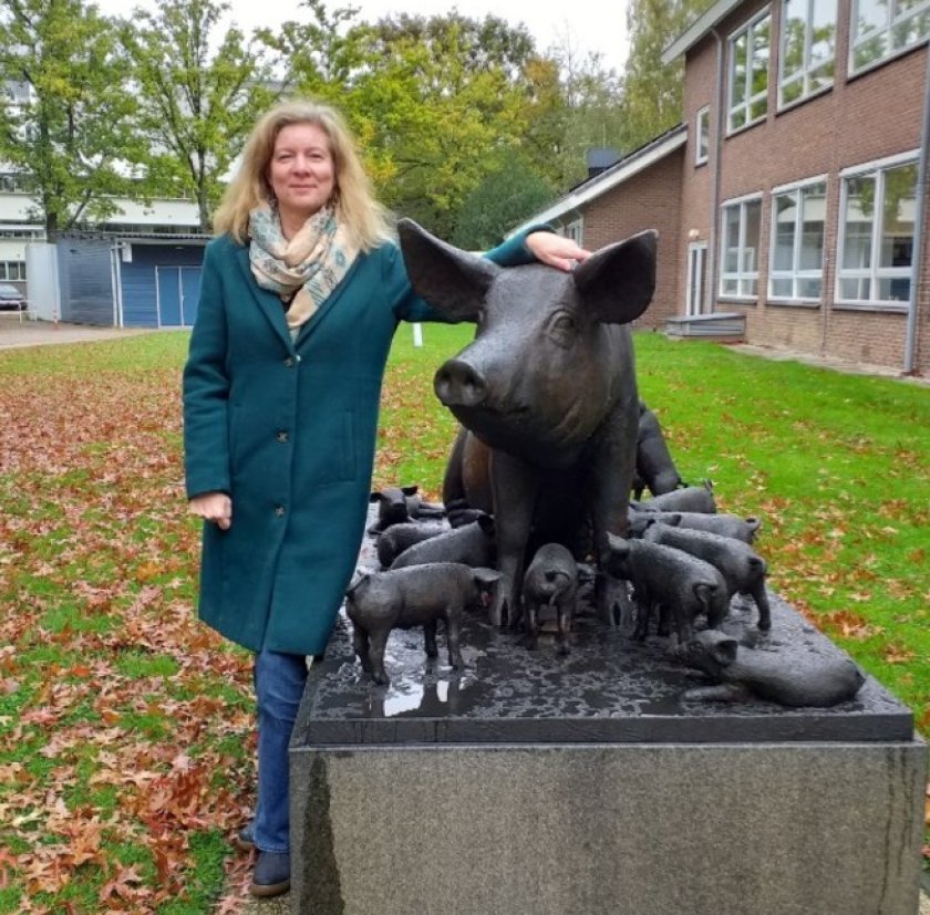 Liesbeth Bolhuis standing at the pig stature on Wageningen campus